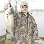 Hunter Miller, a Johnson cousin, shows off a nice-sized hybrid striped bass caught in the lake.