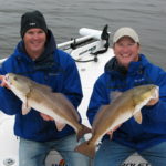 Capt. Charlie Thomason (right) and Capt. Joe Vinson with a pair of wintertime reds.