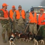 Once the beagles are leashed, Anthony Sharp discusses with his hunting group how they will set up once the dogs jump a rabbit.