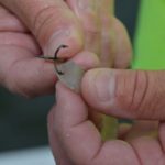 3. Insert one prong of the treble hook into the cut end and out through the top of the plastic lure.