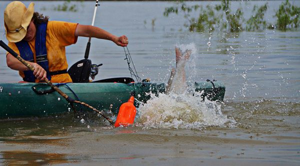 Robyn Bordelon does battle with a big cat while pulling one of her jug lines in the Mississippi River.