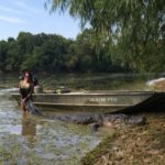 Christina Rivers holds the big 14-foot alligator she and her dad, Roger Rivers, harvested on Sept. 20 north of Toledo Bend. Their boat is a 17-foot Grizzly.