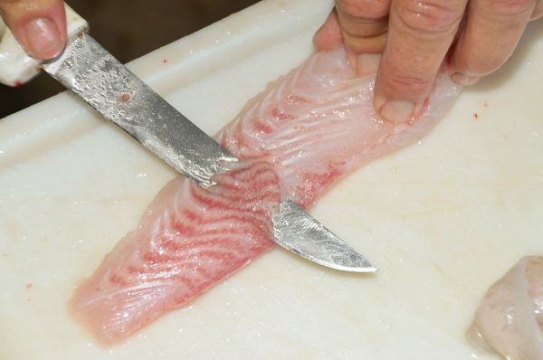 6) Turn each strip skin-side-up, and thinly trim off and discard all reddish flesh.