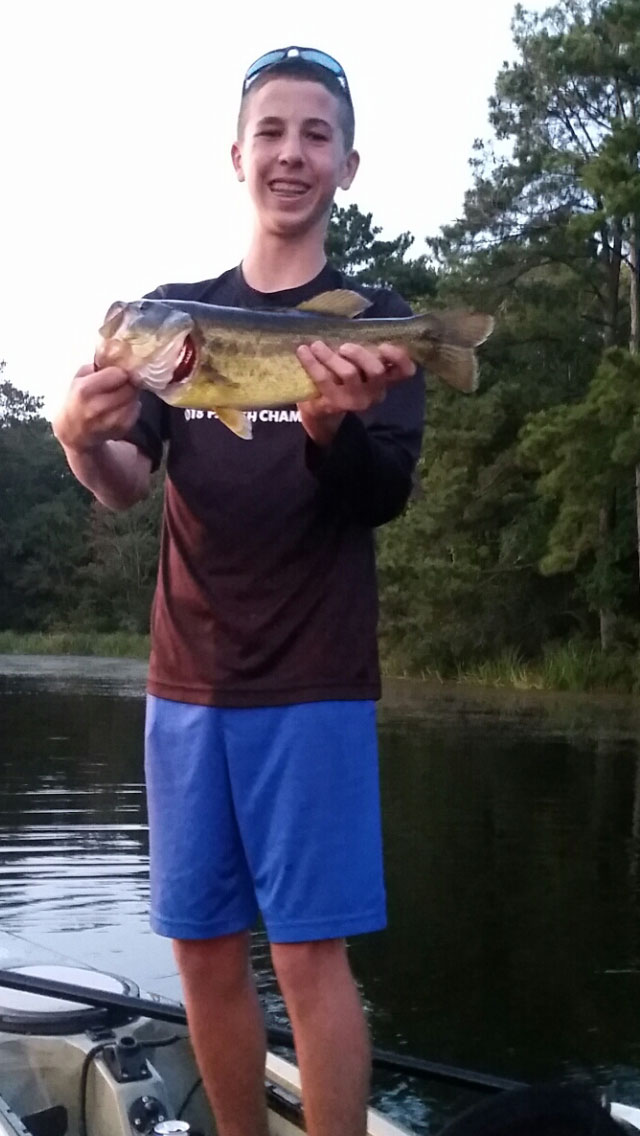 Logan Anderson with a nice bass he caught out of his kayak while fishing with his dad, paw paw and parrain.