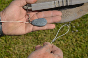 Texas rigs are built with a weight hammered on one end of a heavy monofilament line and a loop crimped on the other end. For storage, the weight is slid on the line up near the decoy body. The loop of each decoy is snapped on a carabiner clip until a manageable number is reached. 