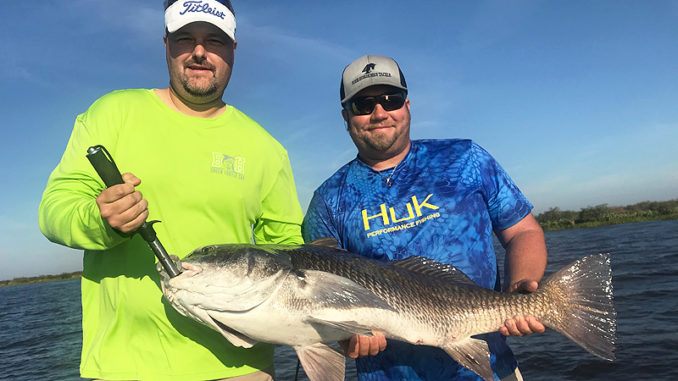 Capt. Nick Rando (right), owner of Fishaholic Fishing Charters, with Allen Buckley and a 45-pound black drum caught on shrimp under a Four-Horsemen popping cork in the Lost Lake area.