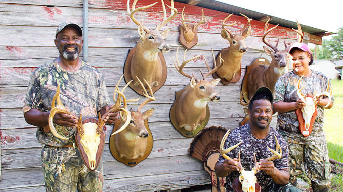 From left, William, Lionel and Jenni Washington show off some of the family’s recent Louisiana whitetail trophies.