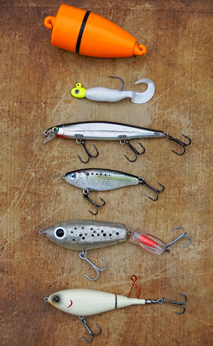 These five lures are proven producers for trout and redfish all across the Louisiana coast for winter fishing trips. Beneath the VersaMaxx cork is a Gulp Swimming Mullet, a Rapala Shadow Wrap jerkbait, the MirrOdine Skin Series shad, a broken-back Corky and finally a Berkley Choppo 90.