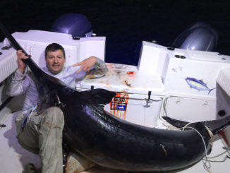 Chris Negulescu poses with the massive 328.4-pound broadbill swordfish he landed along with his nephew, Alex Negulescu, and Eric Hebert, Saturday out of Venice.