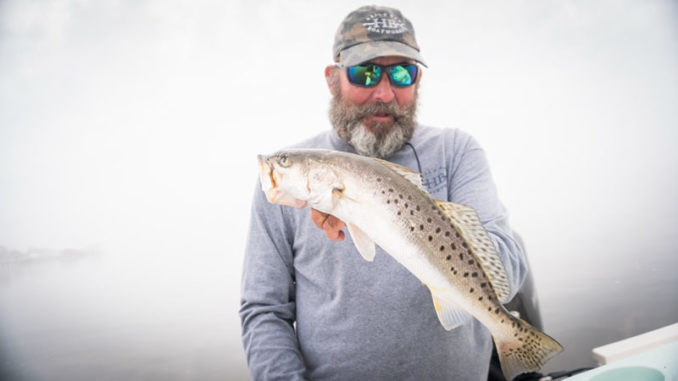 Jeff Poe on a foggy day with a nice speckled trout.