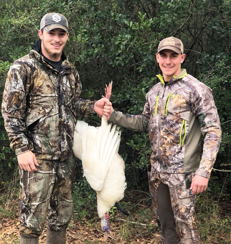 Hunter Waltman (left) and Toby Cagle pose with the rare white gobbler that Waltman killed on March 17, 2019.