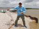 Clay Peltier prepares to throw a cast net at the Big Dam along Bird Island Bayou in Marsh Island.