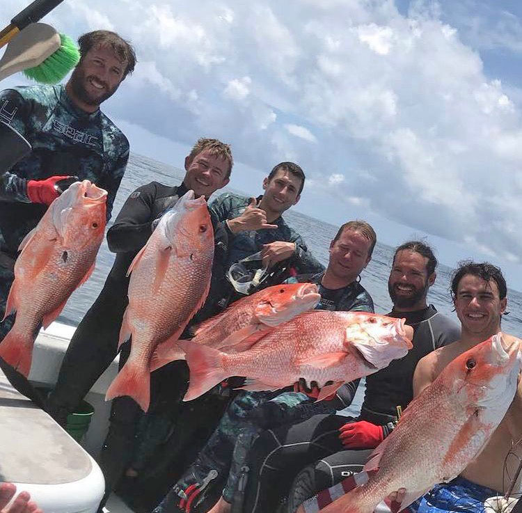 Capt. Brett Ryan, second from right, and a group of friends show the kind of snapper that he is used to harvesting both by rod and reel and by scuba diving.