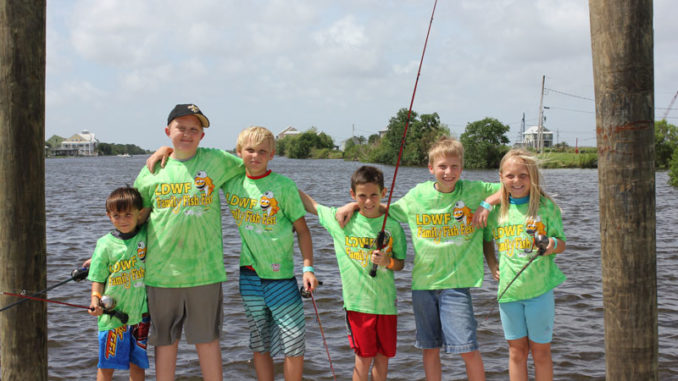 Participants from a Family Fish Fest take a quick break from fishing to pose for a picture. (Photo courtesy LDWF)