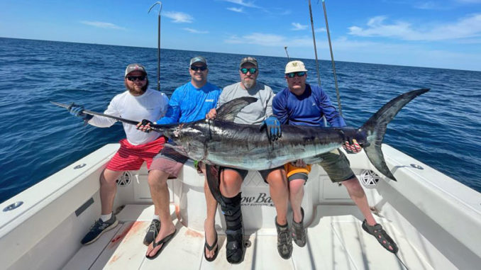 (Left to right) Derrick Dell, Jimmy Brown, William Tucker and Todd Merseal with the big swordfish Dell pulled in.