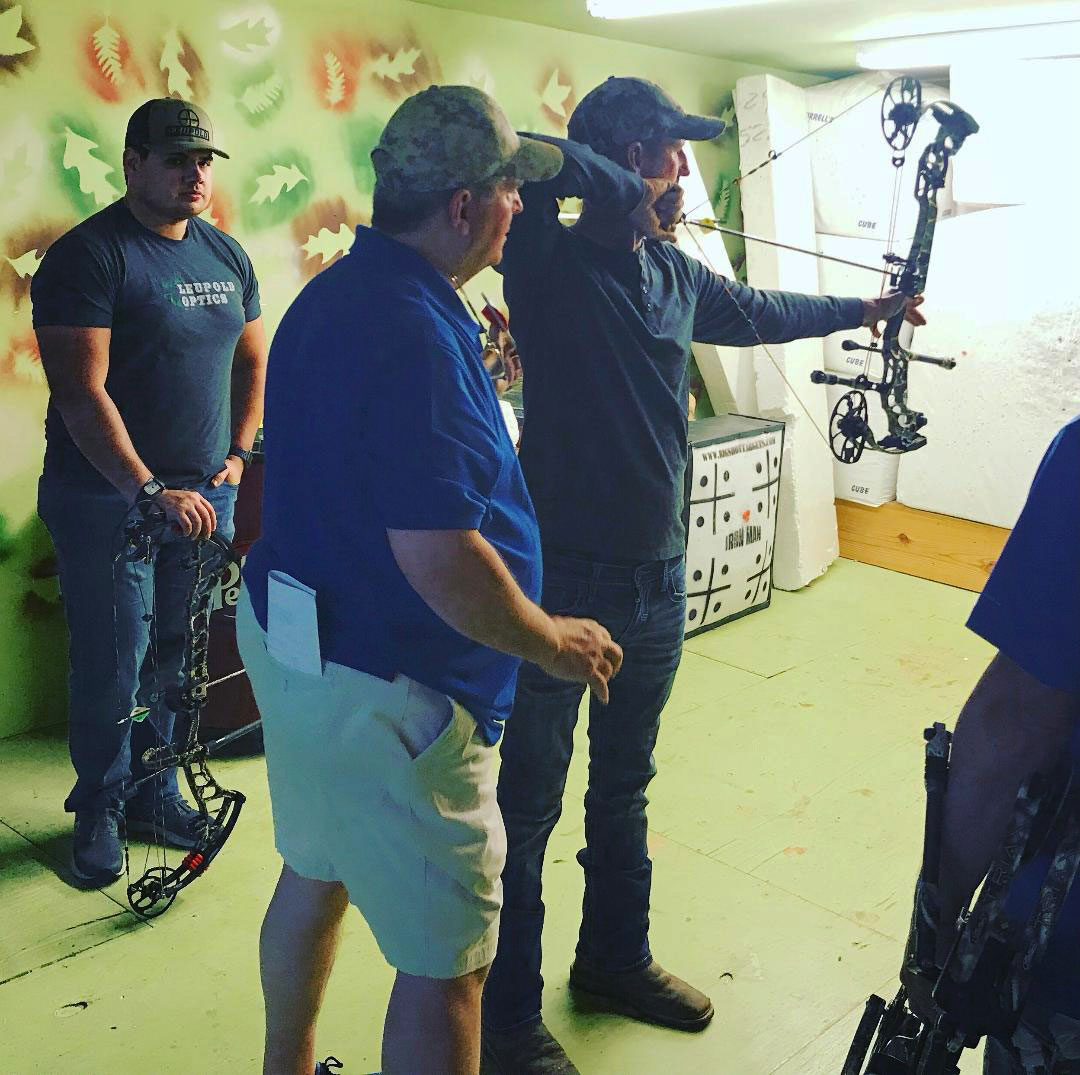 Rod Jenkins gives a shooter tips at an indoor archery range as part of a clinic, one of many the 14-time national champion puts on annually.