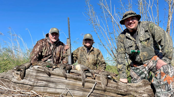 Successful hunters pose with their kill after a hunt with Ryan Lambert.