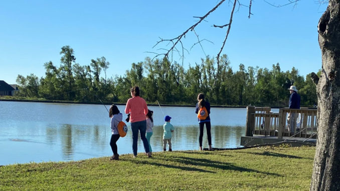 A family fishing together at the Bayou Country Sports Complex in Houma after it was recently stocked with adult-sized channel catfish.