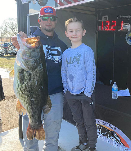 Dusty Nomey shares the moment of catching his monster 13.21-pound largemouth from Caney Lake with his son, Cruz.