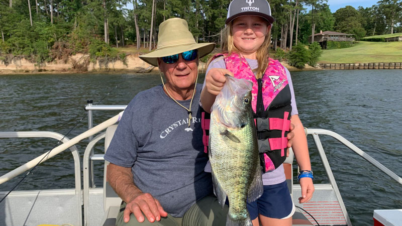 Emily helps her grandpa with his big sac-a-lait on recent trip on Toledo Bend.