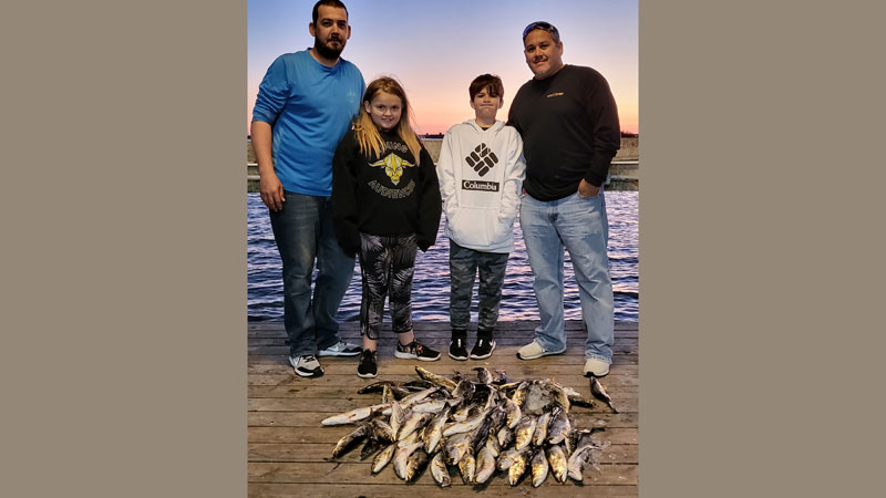 Keith Arabie (right) and his son Drew Arabie, 12, along with James Helmer (left) and his daughter, Allie, 10, went out on a evening fishing trip out of Sweetwater Marina in Delacroix before school starts.