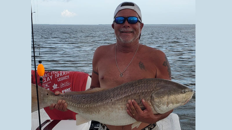 Farley Dennis with a bull redfish from a Delacroix fishing trip on July 30, 2022.