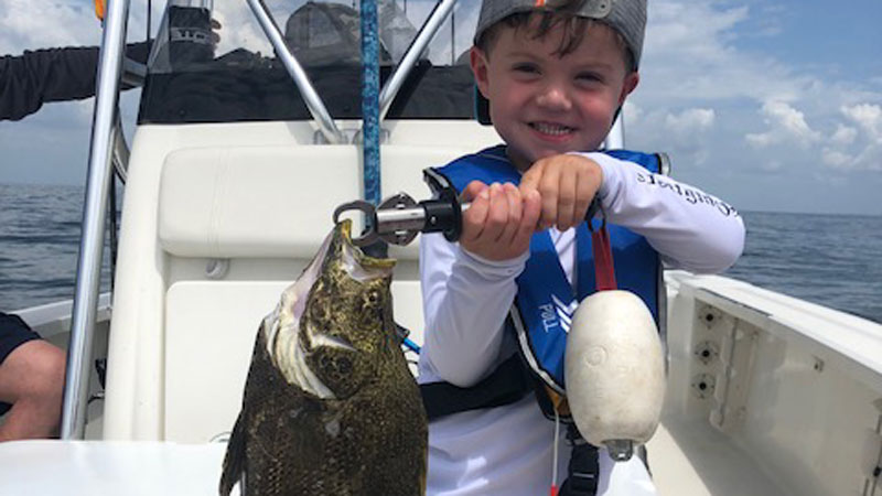 Four-year-old Wills Powell with his first tripletail caught around Flatboat Key under a crab trap buoy.