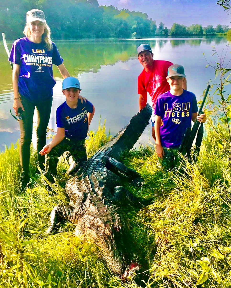 Nicholas Merz (with gun) harvested this 11-foot, 6-inch gator on Somerset Plantation, shown here with his mom, Telly, his dad, Peter, and his brother Henry.