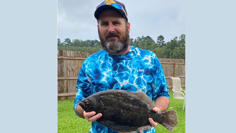 Jason Davis with a flounder he caught on the side of Hwy. 1 in Grand Isle.