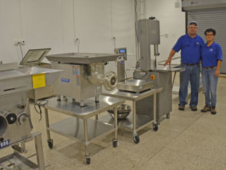 Thomas Hymel and Evelyn Watts of the LSU AgCenter and Sea Grant, stand next to equipment in the Seafood Processing Demonstration Lab in Jeanerette. (Photo courtesy of LSU AgCenter)