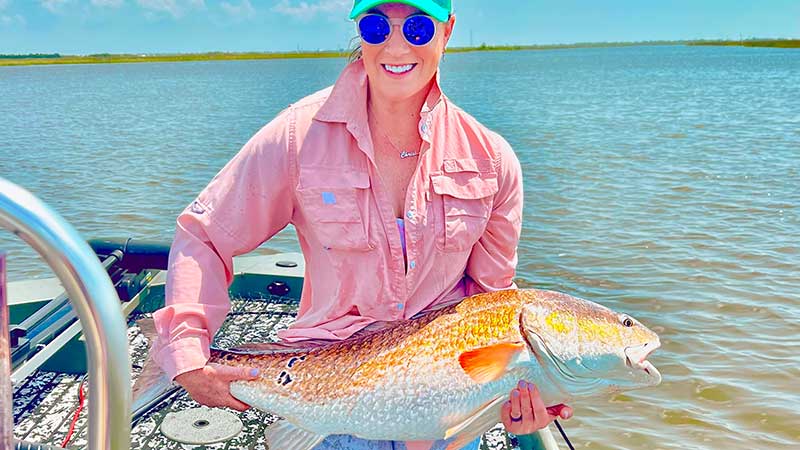 Christina Meladine with a bull red caught this summer fishing out of Happy Jacks in Port Sulphur.