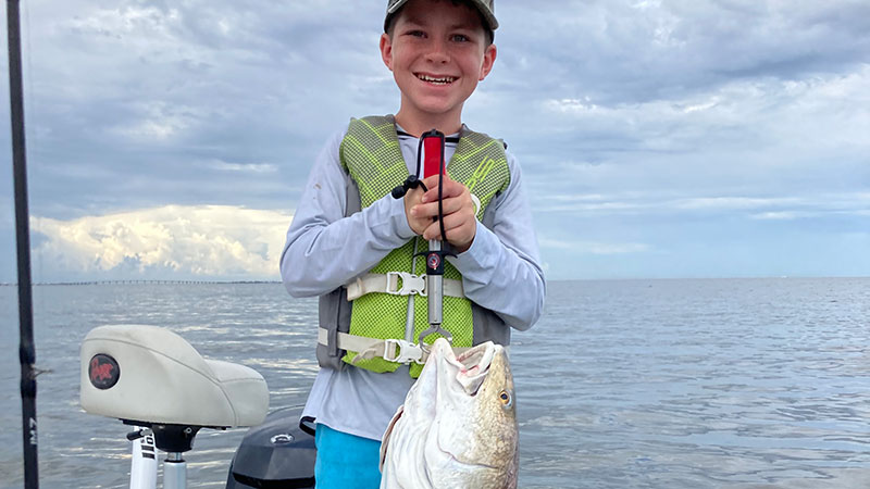 Colt Prejean with his first redfish caught on a family trip to Grand Isle in July.