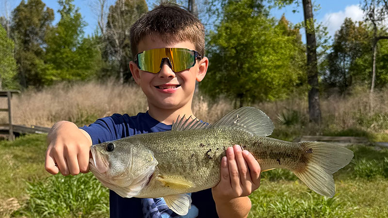 Cayson Harris with the bass he caught from a public pond in Lake Charles while out fishing with his dad on March 20.