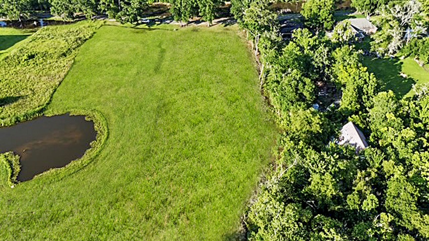 7.863 acre lot with water access to New River leading to Diversion Canal, house pad, pond, and space for your house and shop