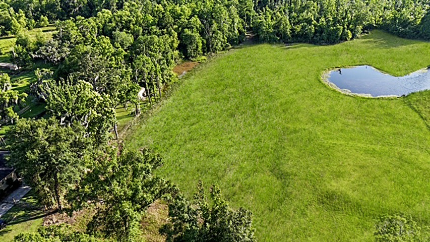 7.863 acre lot with water access to New River leading to Diversion Canal, house pad, pond, and space for your house and shop